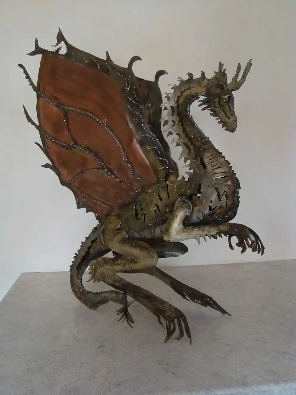 Créature mythologique en acier corten, écailles travaillées