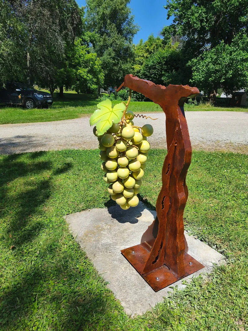 Structure viticole en corten et inox, feuilles et grappes sculptées